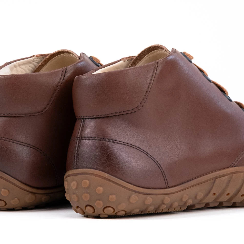 Pair of brown leather shoes with beige soles on a white background