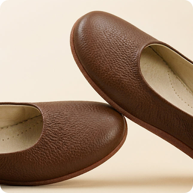 Pair of brown leather shoes on a beige background