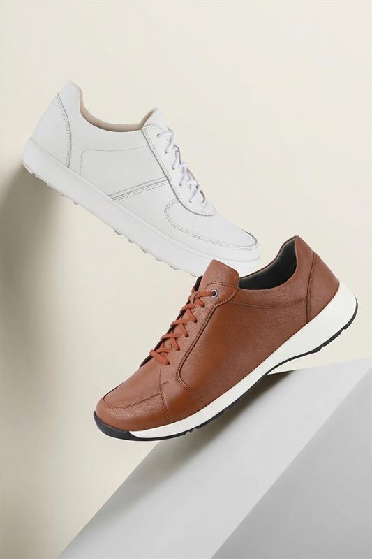White and brown sneakers on a light beige background
