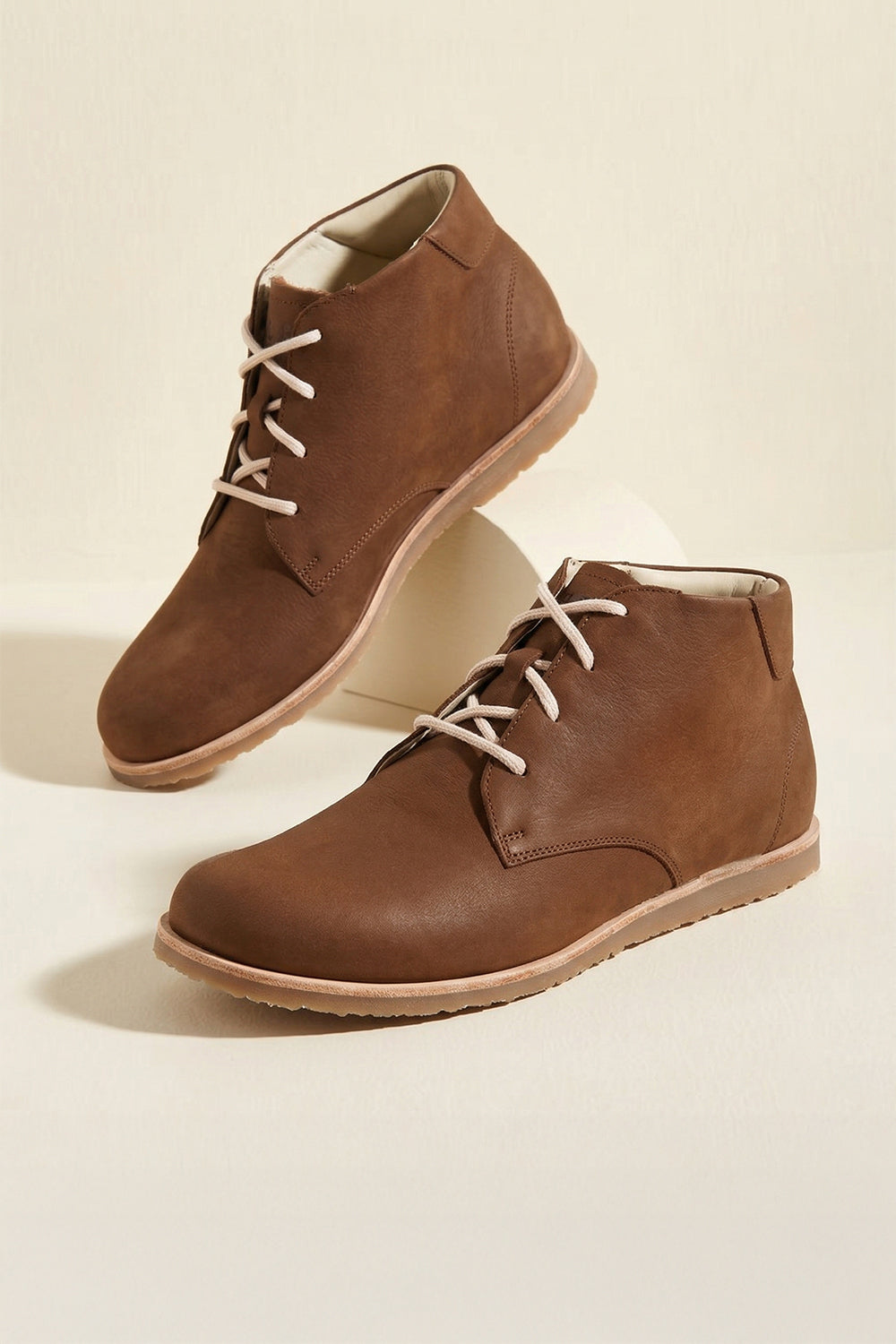Pair of brown leather boots on a beige background